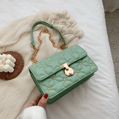 Stílusos kézitáska fém díszítéssel és hosszú fogantyúval