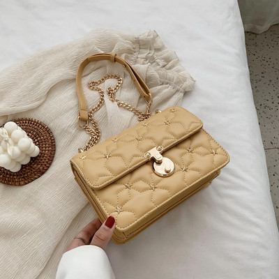 Stílusos kézitáska fém díszítéssel és hosszú fogantyúval