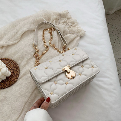 Stílusos kézitáska fém díszítéssel és hosszú fogantyúval