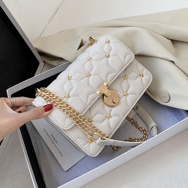 Stílusos kézitáska fém díszítéssel és hosszú fogantyúval