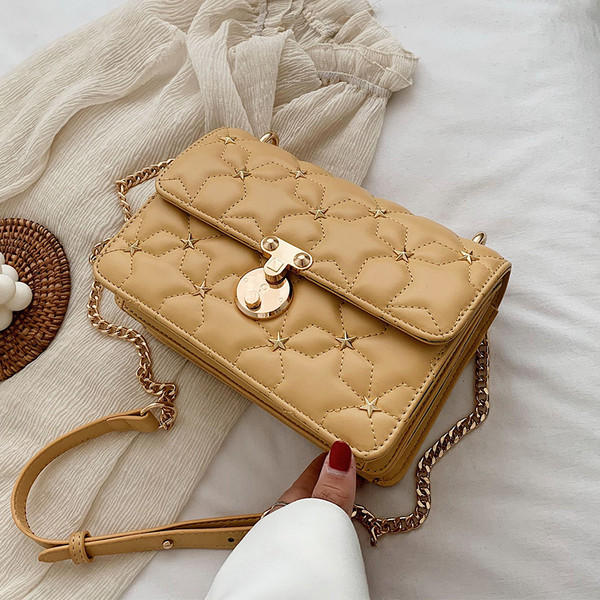 Stílusos kézitáska fém díszítéssel és hosszú fogantyúval