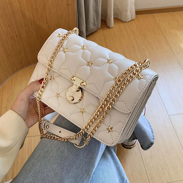 Stílusos kézitáska fém díszítéssel és hosszú fogantyúval