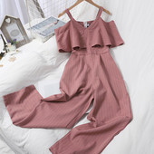 Dugi ženski kombinezon s kovrčama i golim ramenima