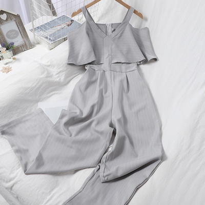 Dugi ženski kombinezon s kovrčama i golim ramenima