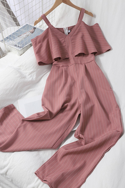 Dugi ženski kombinezon s kovrčama i golim ramenima