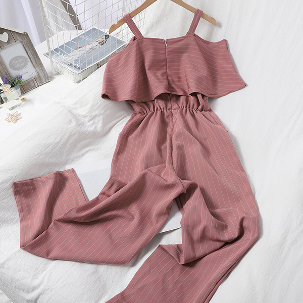 Dugi ženski kombinezon s kovrčama i golim ramenima