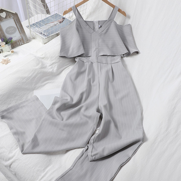 Dugi ženski kombinezon s kovrčama i golim ramenima