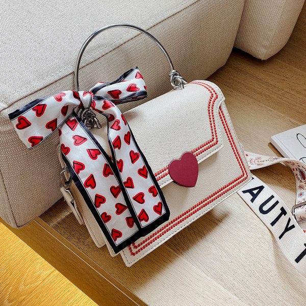 Moderna sieviešu soma ar lenti un īsu metāla rokturi