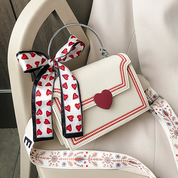 Moderna sieviešu soma ar lenti un īsu metāla rokturi