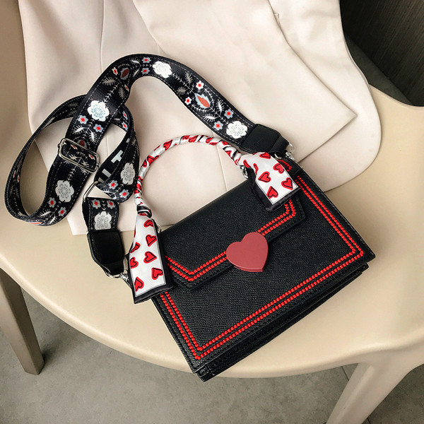 Moderna sieviešu soma ar lenti un īsu metāla rokturi