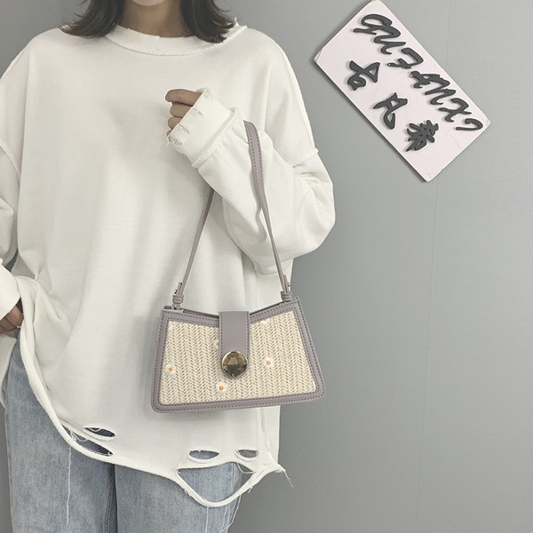 Kövekkel és hímzéssel díszített női táska rövid fogantyúval és fém csattal