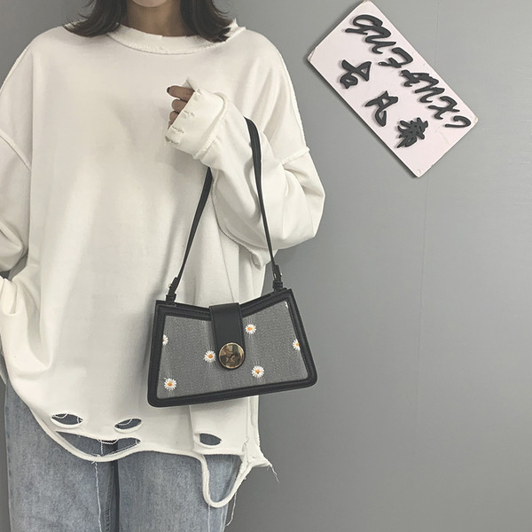 Kövekkel és hímzéssel díszített női táska rövid fogantyúval és fém csattal