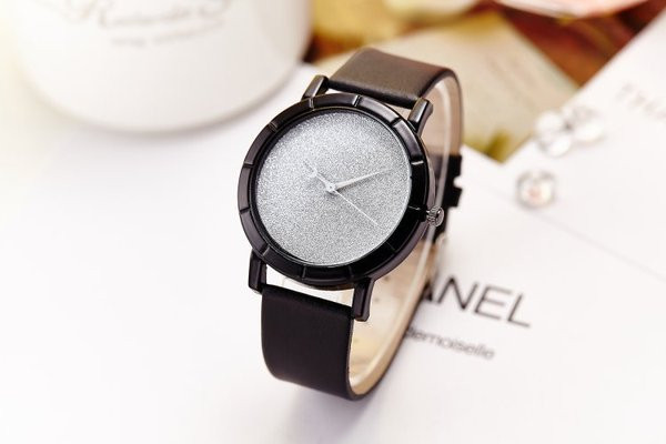 Pulkstenis ar spīdīgām daļiņām un ādas siksniņu