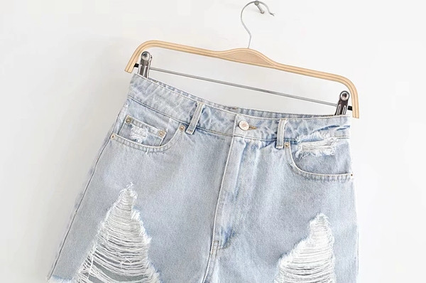 Jauns sieviešu džinsa šortu modelis ar saplēstiem motīviem zilā krāsā