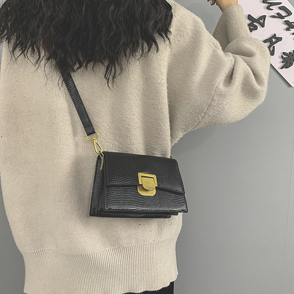 Moderna ženska kožna torba s metalnim kopčanjem i dugom ručkom