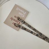 Női öv kígyómintával és fém gyűrűvel