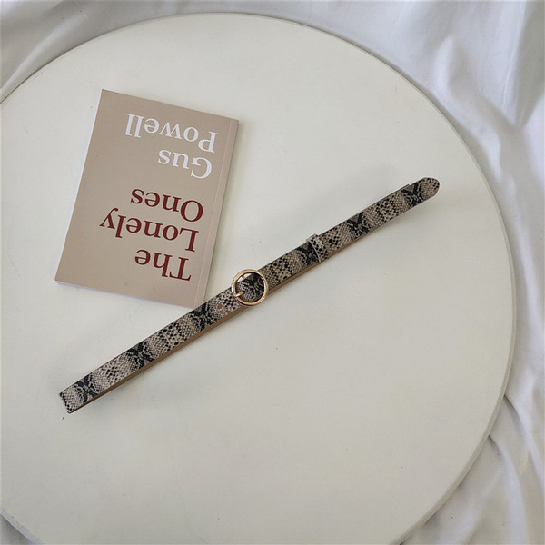 Női öv kígyómintával és fém gyűrűvel