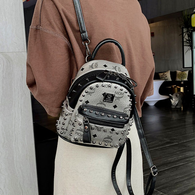 Női hátizsák elülső zsebbel és fém elemmel