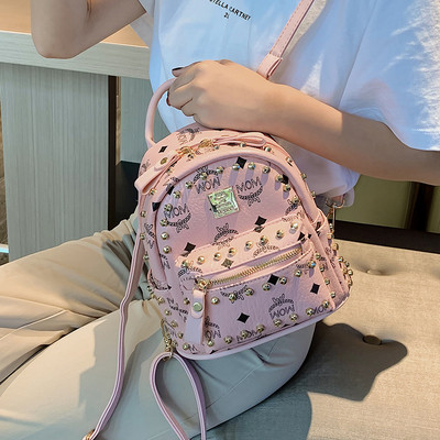 Női hátizsák elülső zsebbel és fém elemmel