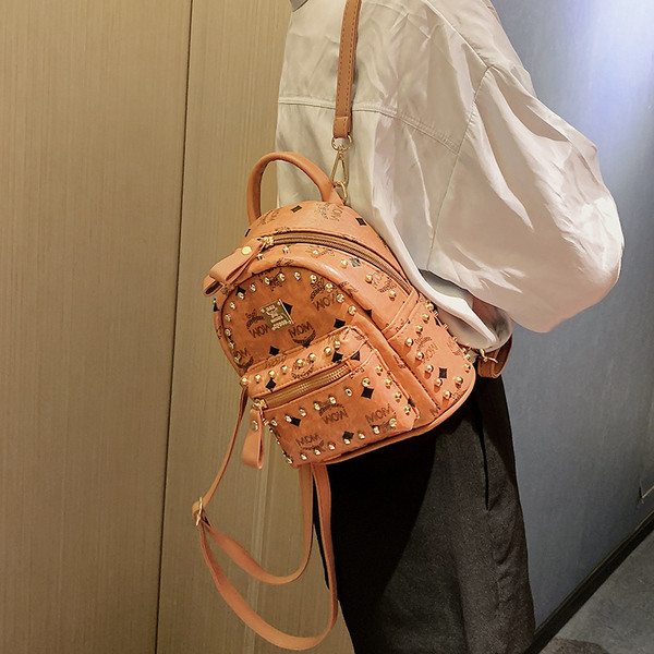 Női hátizsák elülső zsebbel és fém elemmel