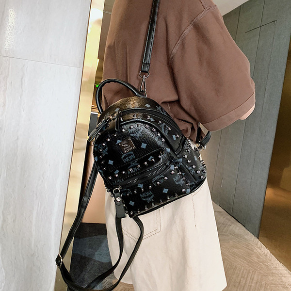 Női hátizsák elülső zsebbel és fém elemmel