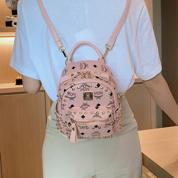 Női hátizsák elülső zsebbel és fém elemmel