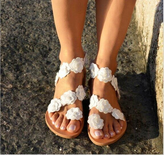 Új szandálmodell lapos talppal és virágdíszítéssel
