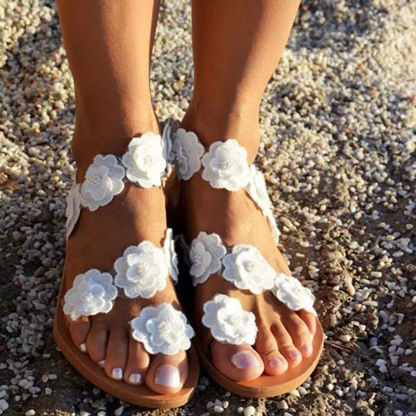 Új szandálmodell lapos talppal és virágdíszítéssel