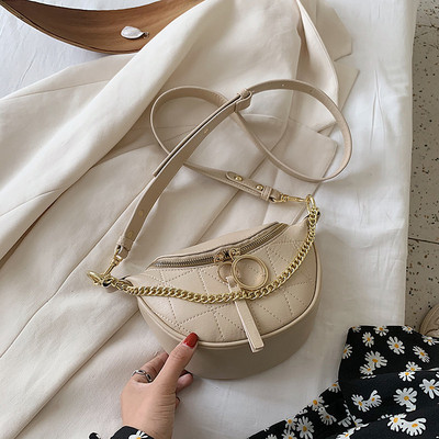 Mala ženska torba sa metalnim elementima i dugom ručkom