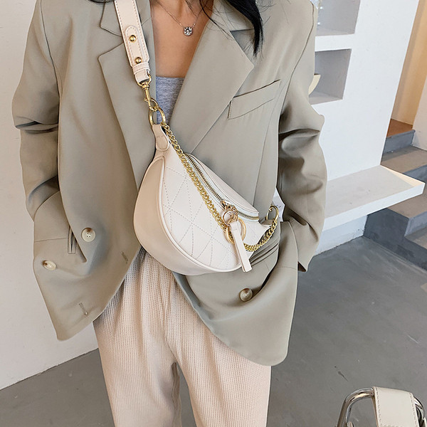 Mala ženska torba sa metalnim elementima i dugom ručkom