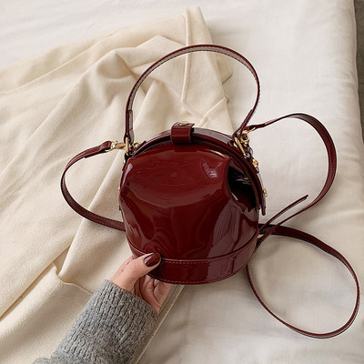 Ženska moderna okrugla lakirana kožna torba