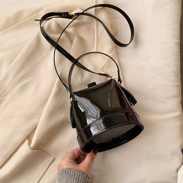 Ženska moderna okrugla lakirana kožna torba