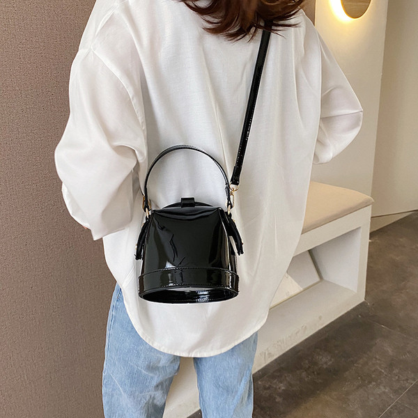 Ženska moderna okrugla lakirana kožna torba