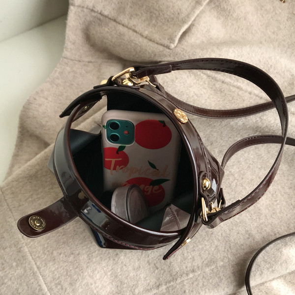 Ženska moderna okrugla lakirana kožna torba