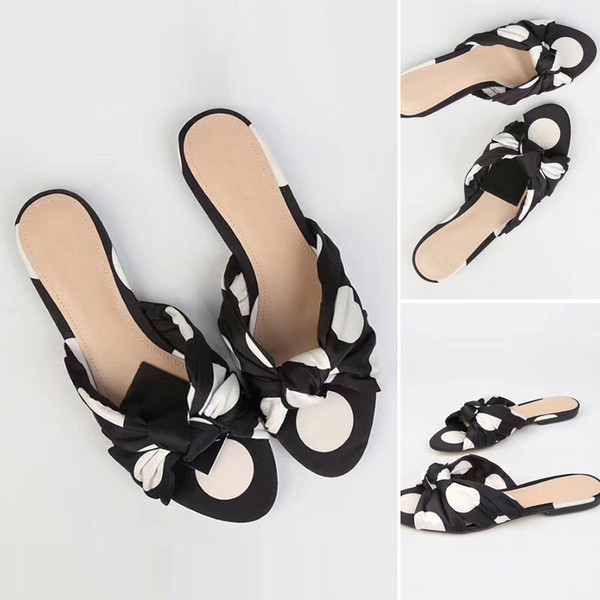 Textilből készült lapos talpú női papucs csomóval