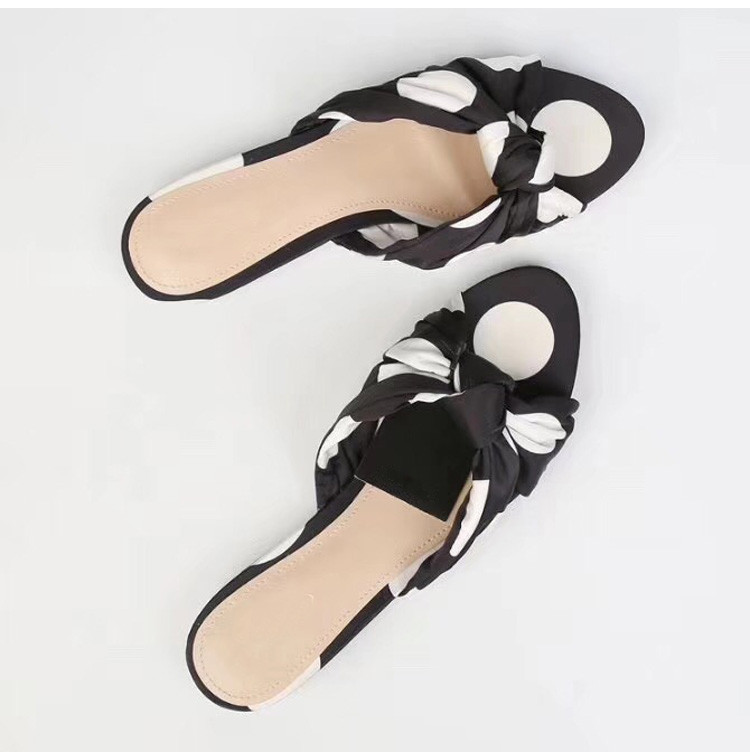 Textilből készült lapos talpú női papucs csomóval