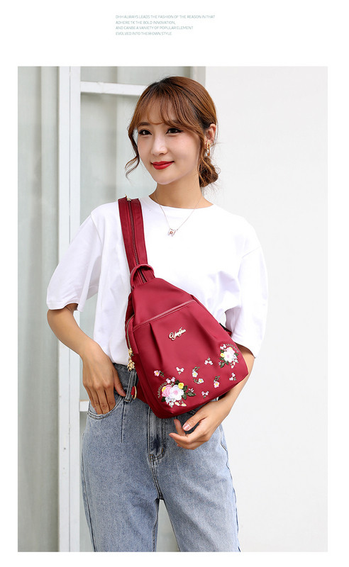 Modern női hátizsák fém felirattal és virágos hímzéssel