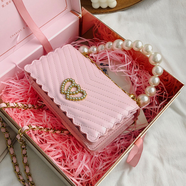 Stílusos kézitáska díszgyöngyökkel és csattal