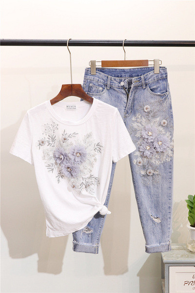 Šiuolaikiškas moteriškas rinkinys, kurį sudaro marškinėliai ir džinsai su gėlėmis
