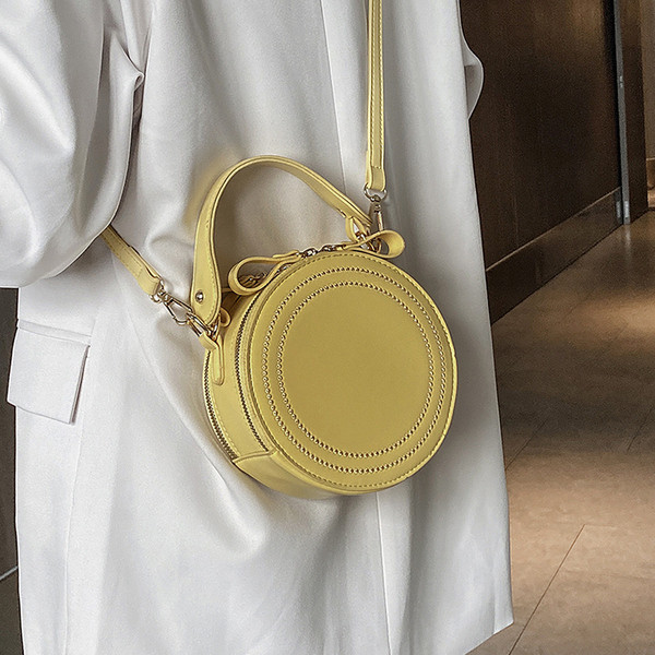 Apaļa sieviešu soma ar cilpām un rāvējslēdzējiem