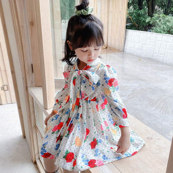 Mūsdienīgs bērnu kleitas piegriezuma modelis ar lentīti un garām piedurknēm