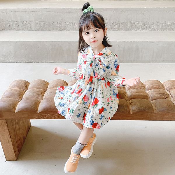 Mūsdienīgs bērnu kleitas piegriezuma modelis ar lentīti un garām piedurknēm