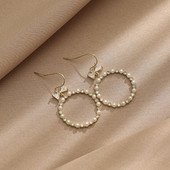 Egyszerű női kerek fülbevaló gyöngyökkel és szalaggal