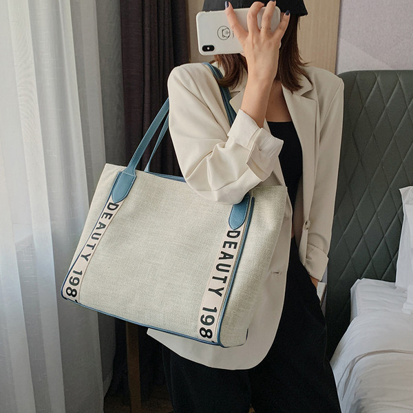 Napi női táska bőr füllel és feliratokkal