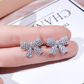 Moderni sieviešu auskari lentes formā, kas apvilkta ar akmeņiem