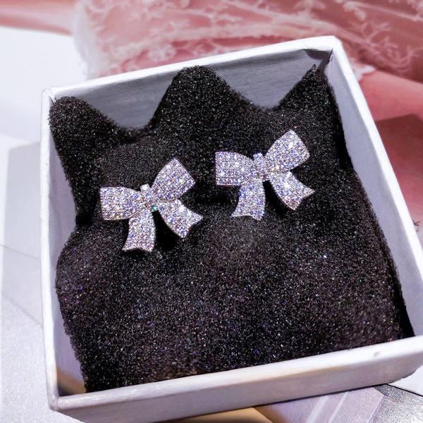 Moderni sieviešu auskari lentes formā, kas apvilkta ar akmeņiem