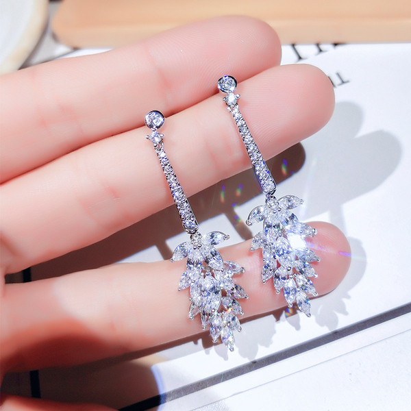 Eleganti sieviešu karājas auskari, kas pārklāti ar akmeņiem