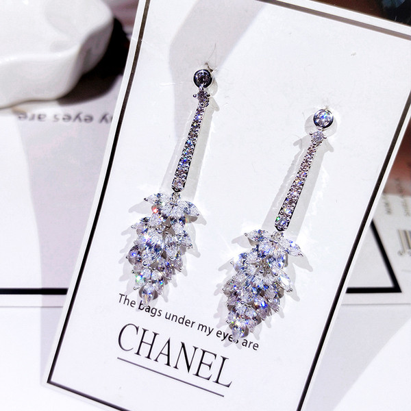 Eleganti sieviešu karājas auskari, kas pārklāti ar akmeņiem