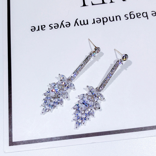 Eleganti sieviešu karājas auskari, kas pārklāti ar akmeņiem