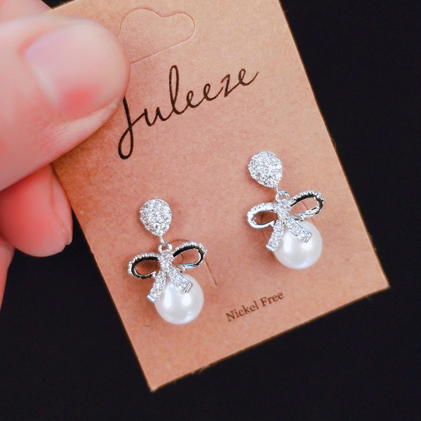 Vienkārši sieviešu auskari ar pērli un lenti ar akmeņiem